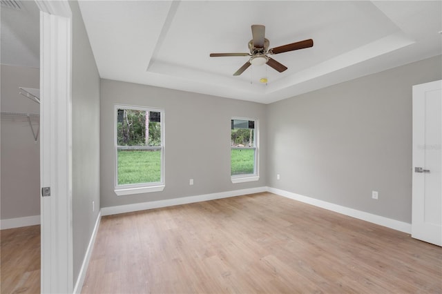 9299 N Tahiti Way, Citrus Springs, FL 34433 - empty room with a tray ceiling, light wood finished floors, ceiling fan, and baseboards