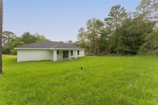 9299 N Tahiti Way, Citrus Springs, FL 34433 - rear view of property with a yard and stucco siding