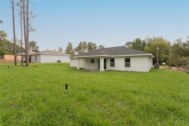 9299 N Tahiti Way, Citrus Springs, FL 34433 - back of property with a lawn and central AC unit