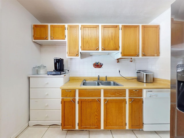 720 Meadow St, Sanford, FL 32773 - kitchen featuring dishwasher, light countertops, backsplash, light tile patterned flooring, and brown cabinets