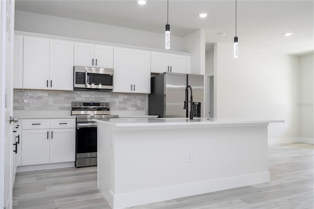 10333 N Halsey Way, Citrus Springs, FL 34434 - kitchen featuring stainless steel appliances, light countertops, tasteful backsplash, a kitchen island with sink, and white cabinetry