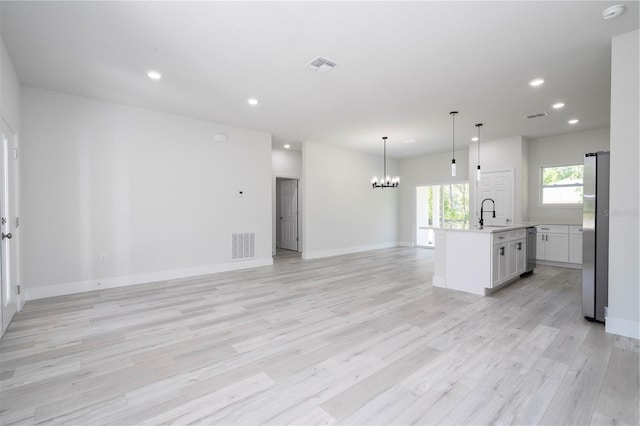 10333 N Halsey Way, Citrus Springs, FL 34434 - unfurnished living room with a chandelier, recessed lighting, light wood-style floors, baseboards, and a sink