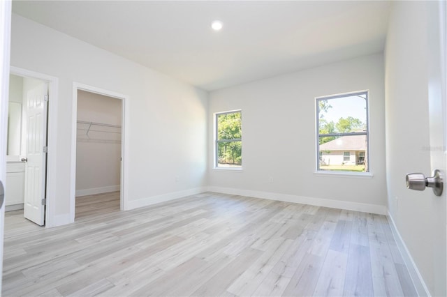 10333 N Halsey Way, Citrus Springs, FL 34434 - unfurnished bedroom featuring light wood finished floors, a walk in closet, baseboards, a closet, and recessed lighting
