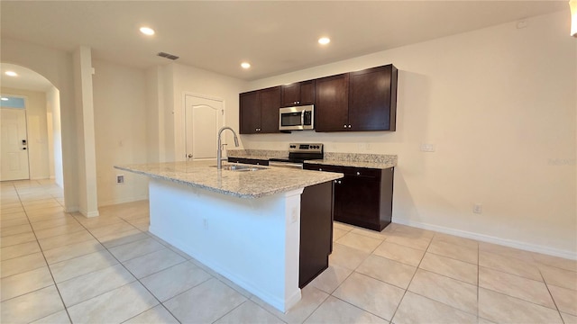 3202 Timber Hawk Cir, Ocoee, FL 34761 - kitchen with appliances with stainless steel finishes, a sink, arched walkways, an island with sink, and recessed lighting