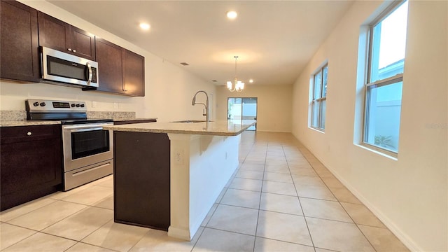 3202 Timber Hawk Cir, Ocoee, FL 34761 - kitchen featuring appliances with stainless steel finishes, a sink, light stone counters, light tile patterned floors, and recessed lighting