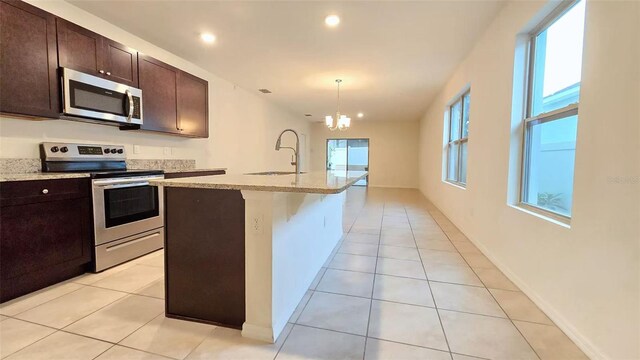 3202 Timber Hawk Cir, Ocoee, FL 34761 - kitchen featuring appliances with stainless steel finishes, a chandelier, dark brown cabinetry, light tile patterned flooring, and recessed lighting