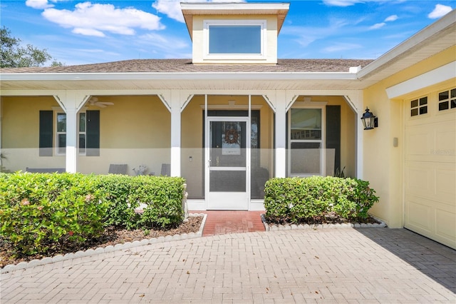 217 Lake Cassidy Dr, Kissimmee, FL 34759 - view of exterior entry featuring roof with shingles, stucco siding, and covered porch