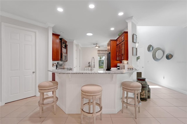 217 Lake Cassidy Dr, Kissimmee, FL 34759 - kitchen with stainless steel appliances, light tile patterned floors, light stone countertops, baseboards, and recessed lighting