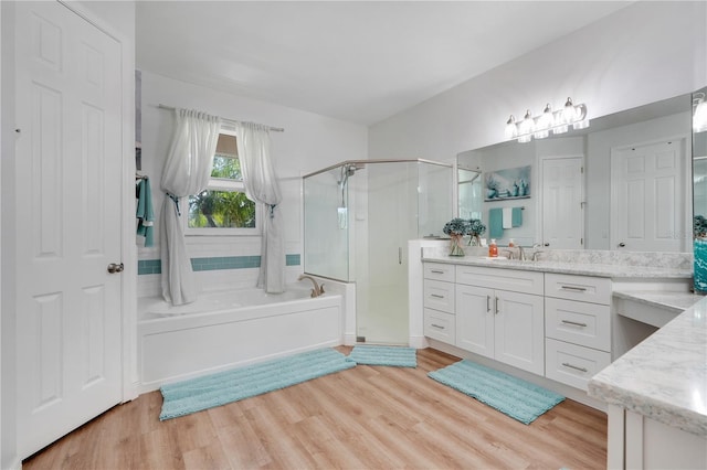 217 Lake Cassidy Dr, Kissimmee, FL 34759 - bathroom featuring a shower stall, vanity, a garden tub, and wood finished floors