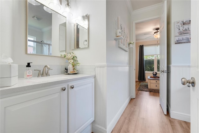 217 Lake Cassidy Dr, Kissimmee, FL 34759 - bathroom with ornamental molding, wood finished floors, vanity, a wainscoted wall, and ceiling fan