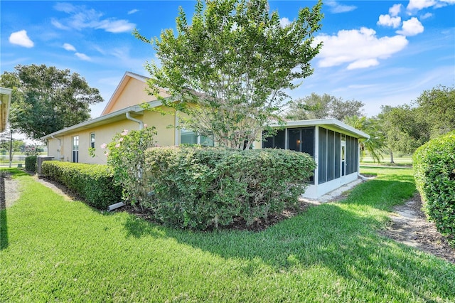 217 Lake Cassidy Dr, Kissimmee, FL 34759 - view of property exterior featuring a sunroom, a yard, stucco siding, and central AC