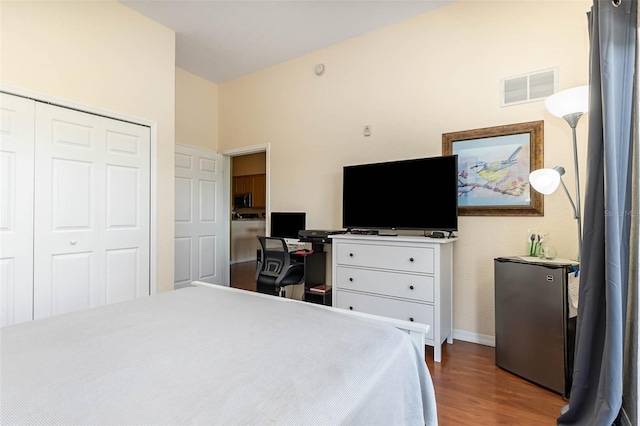 9051 Treasure Trove Ln Unit 505, Kissimmee, FL 34747 - bedroom with dark wood finished floors, a closet, baseboards, freestanding refrigerator, and an office area