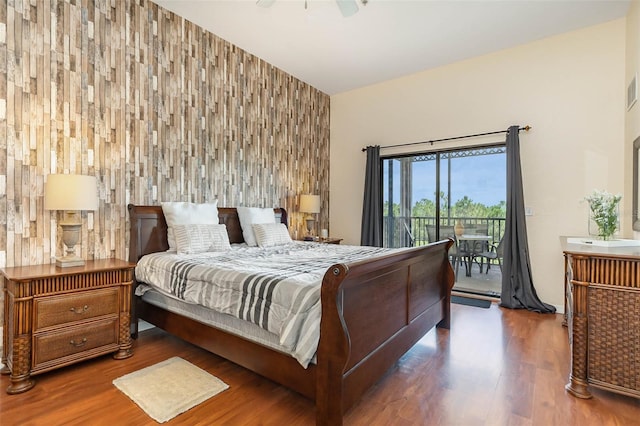 9051 Treasure Trove Ln Unit 505, Kissimmee, FL 34747 - bedroom featuring access to outside, wood finished floors, an accent wall, and a ceiling fan