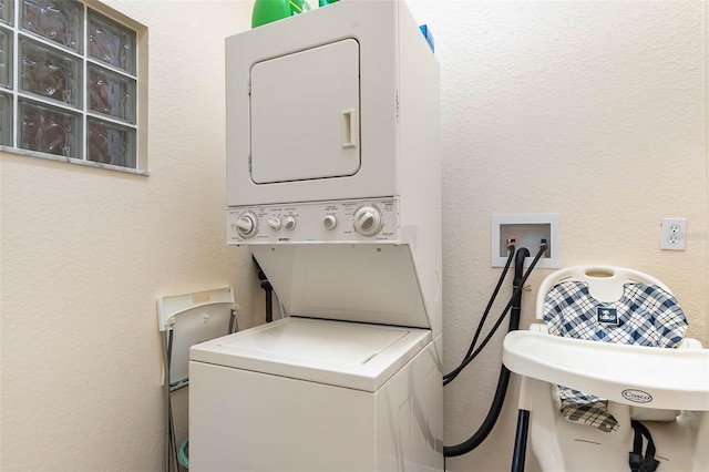 9051 Treasure Trove Ln Unit 505, Kissimmee, FL 34747 - laundry room featuring stacked washing machine and dryer and a textured wall
