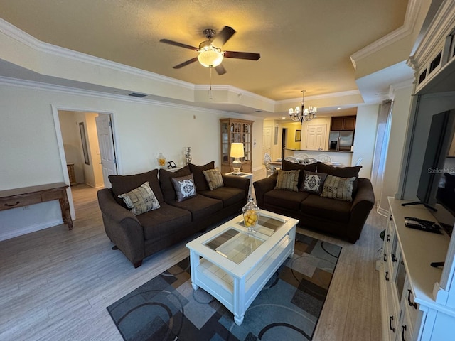 7651 Whisper Way Unit 201, Kissimmee, FL 34747 - living room with a tray ceiling, ornamental molding, light wood finished floors, a ceiling fan, and a chandelier