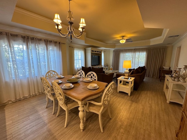 7651 Whisper Way Unit 201, Kissimmee, FL 34747 - dining space featuring a tray ceiling, plenty of natural light, a chandelier, light wood finished floors, and ornamental molding