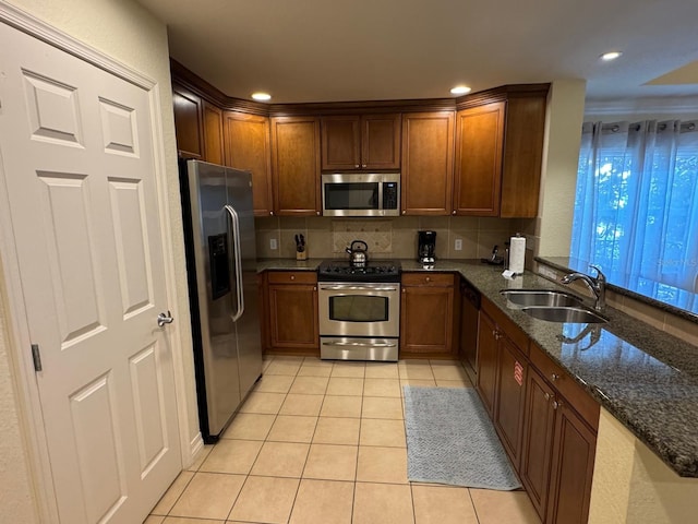 7651 Whisper Way Unit 201, Kissimmee, FL 34747 - kitchen with appliances with stainless steel finishes, a sink, light tile patterned floors, dark stone countertops, and recessed lighting