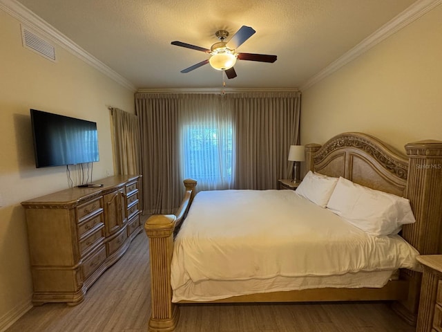 7651 Whisper Way Unit 201, Kissimmee, FL 34747 - bedroom with ornamental molding, light wood-style flooring, a ceiling fan, a textured ceiling, and baseboards