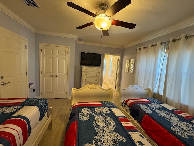 7651 Whisper Way Unit 201, Kissimmee, FL 34747 - bedroom featuring wood finished floors, crown molding, a textured ceiling, and a ceiling fan