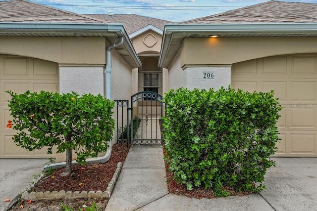 206 Islandia Ct Unit U206, Satellite Beach, FL 32937 - entrance to property featuring a shingled roof, a gate, stucco siding, and a garage