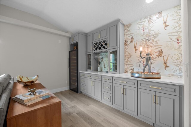 1301 Johns Cove Ln, Oakland, FL 34787 - indoor wet bar with beverage cooler, light wood finished floors, vaulted ceiling, and baseboards