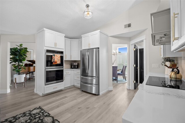 1301 Johns Cove Ln, Oakland, FL 34787 - kitchen featuring appliances with stainless steel finishes, decorative backsplash, light wood-type flooring, and baseboards