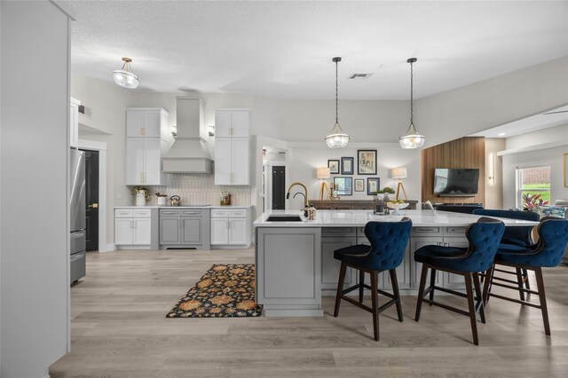 1301 Johns Cove Ln, Oakland, FL 34787 - kitchen featuring custom exhaust hood, a sink, black electric cooktop, backsplash, and light countertops