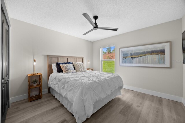 1301 Johns Cove Ln, Oakland, FL 34787 - bedroom with wood finished floors, a textured ceiling, a ceiling fan, and baseboards