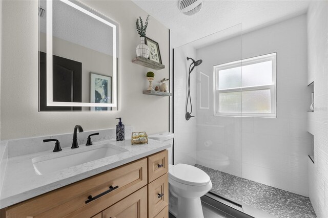 1301 Johns Cove Ln, Oakland, FL 34787 - full bath featuring toilet, vanity, a tile shower, and a textured ceiling