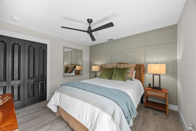 1301 Johns Cove Ln, Oakland, FL 34787 - bedroom featuring light wood finished floors, a decorative wall, ceiling fan, and baseboards