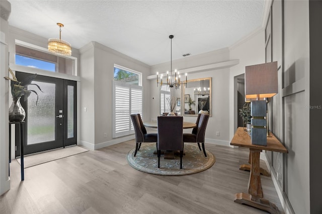 1301 Johns Cove Ln, Oakland, FL 34787 - dining area with a chandelier, crown molding, wood finished floors, a textured ceiling, and baseboards
