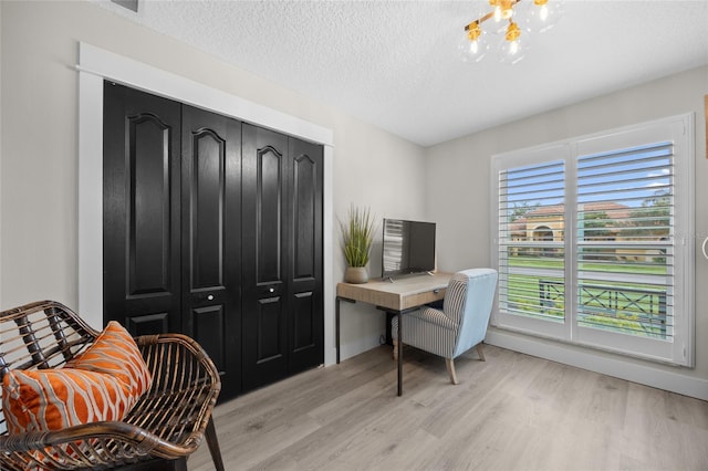 1301 Johns Cove Ln, Oakland, FL 34787 - office featuring light wood finished floors, a chandelier, a textured ceiling, and baseboards