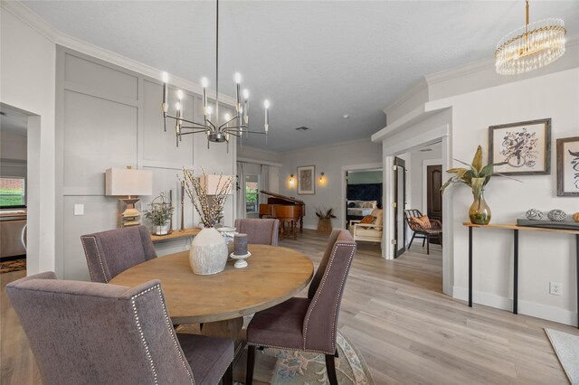 1301 Johns Cove Ln, Oakland, FL 34787 - dining room featuring a chandelier, crown molding, light wood-type flooring, and baseboards