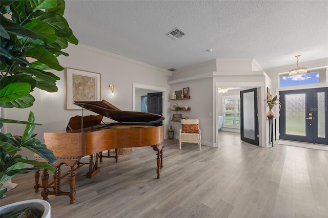 1301 Johns Cove Ln, Oakland, FL 34787 - entryway with wood finished floors, a textured ceiling, ornamental molding, and a chandelier