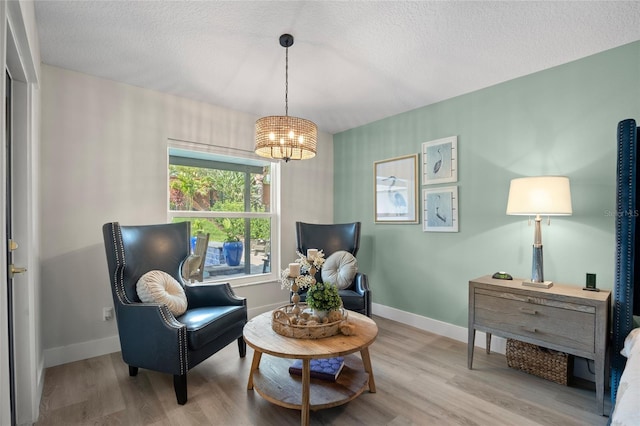 1301 Johns Cove Ln, Oakland, FL 34787 - sitting room featuring a chandelier, wood finished floors, a textured ceiling, and baseboards