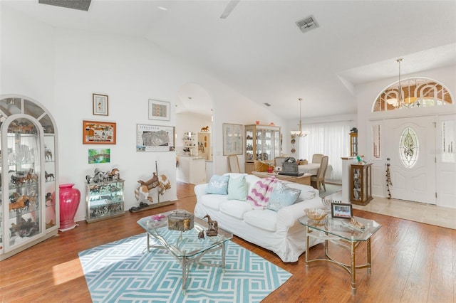109 Hunter Point Ct, Debary, FL 32713 - living area with a chandelier, wood finished floors, arched walkways, and high vaulted ceiling