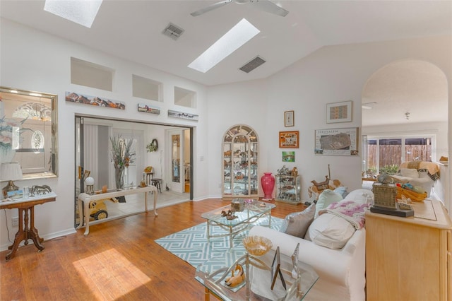 109 Hunter Point Ct, Debary, FL 32713 - living area featuring a skylight, arched walkways, vaulted ceiling, wood finished floors, and ceiling fan