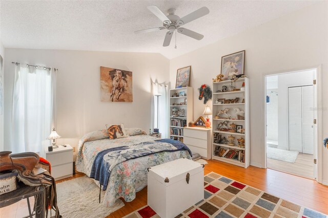 109 Hunter Point Ct, Debary, FL 32713 - bedroom featuring light wood-style floors, lofted ceiling, a textured ceiling, and ceiling fan