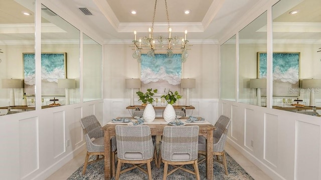 3142 Torta Ct, Bradenton, FL 34211 - dining space featuring a decorative wall, a chandelier, light tile patterned floors, wainscoting, and a raised ceiling