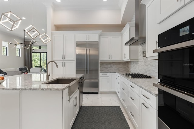 8113 Via Vittoria Way, Orlando, FL 32819 - kitchen featuring stainless steel appliances, wall chimney exhaust hood, light marble finish flooring, crown molding, and white cabinets