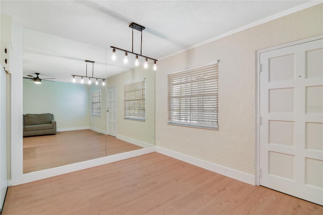 2893 S Osceola Ave Unit E6, Orlando, FL 32806 - unfurnished room with rail lighting, light wood-style floors, ceiling fan, a textured ceiling, and baseboards