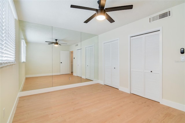 2893 S Osceola Ave Unit E6, Orlando, FL 32806 - unfurnished bedroom featuring light wood-style flooring, multiple closets, and baseboards