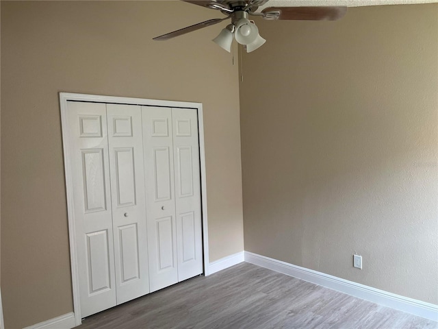 12421 Early Run Ln, Riverview, FL 33578 - unfurnished bedroom featuring wood finished floors, baseboards, a closet, and a ceiling fan
