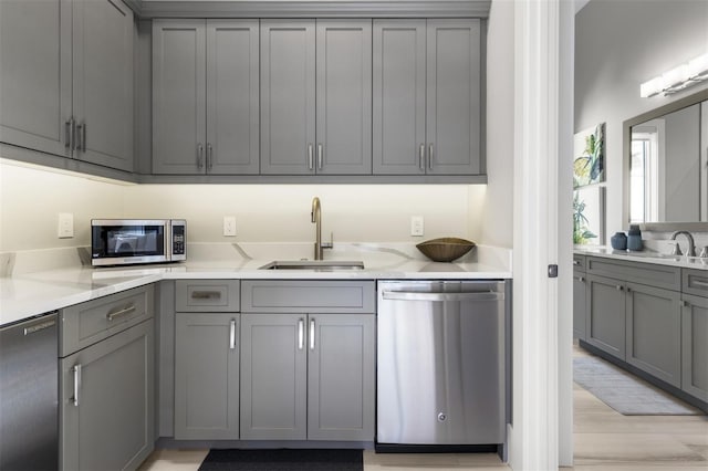 3428 Chaine Du Lac Blvd, Windermere, FL 34786 - kitchen featuring appliances with stainless steel finishes, gray cabinetry, light wood-style floors, and light stone countertops