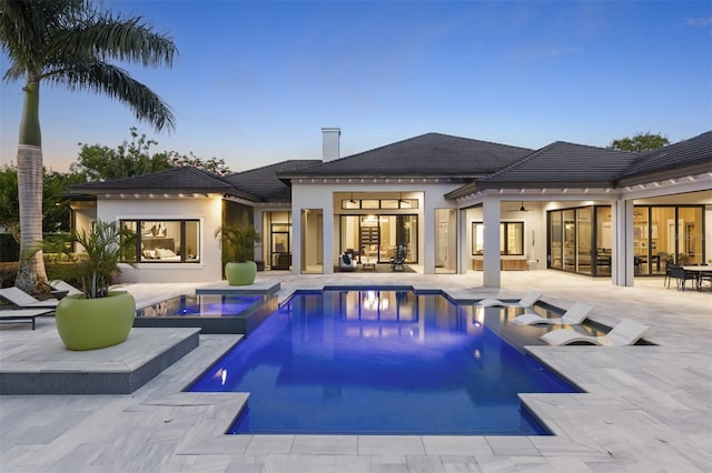 3428 Chaine Du Lac Blvd, Windermere, FL 34786 - back of property featuring a patio, stucco siding, a pool with connected hot tub, and a tile roof