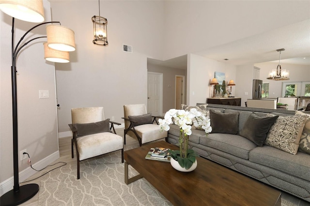 1364 Augusta National Blvd, Winter Springs, FL 32708 - living room featuring a chandelier, baseboards, light wood-style floors, and a towering ceiling