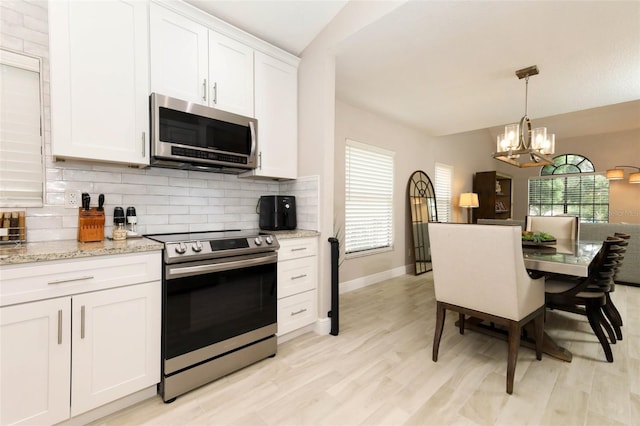 1364 Augusta National Blvd, Winter Springs, FL 32708 - kitchen with appliances with stainless steel finishes, a chandelier, backsplash, white cabinets, and pendant lighting