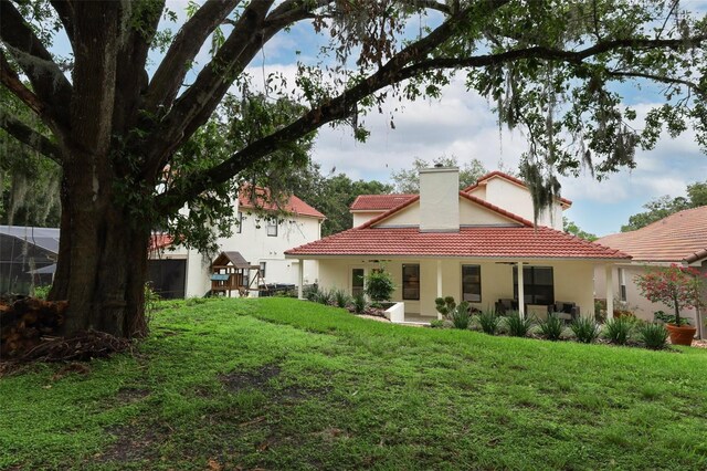 1364 Augusta National Blvd, Winter Springs, FL 32708 - back of property with a tile roof, stucco siding, and a lawn