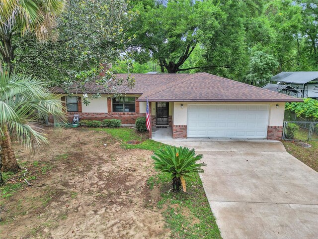 6421 NW 61st St, Ocala, FL 34482 - ranch-style home with brick siding, driveway, a garage, and roof with shingles