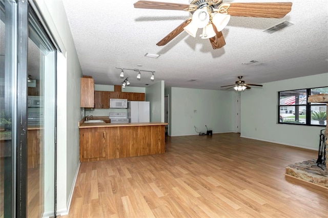 6421 NW 61st St, Ocala, FL 34482 - kitchen with white appliances, brown cabinetry, open floor plan, a sink, and a textured ceiling